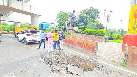 Large pothole and cracked road surface in Indore