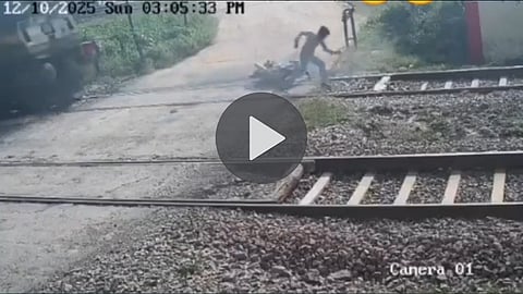 bike-falls-on-railway-track-man-tries-to-pick-up-train-approaches-terrifying-video