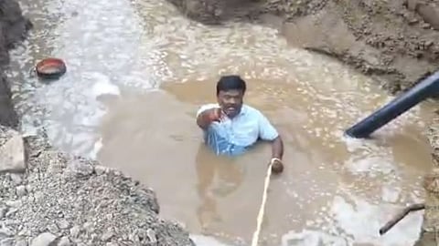 Shiv Sena's Sanjay Upganalawar protests inside a water-filled pit in Yavatmal over Amrut Yojana delays and broken pipelines. 5-day water gap angers citizens.