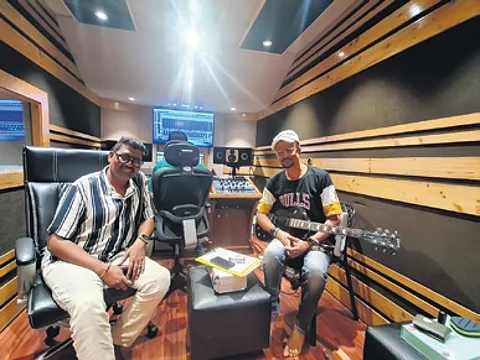 Musician Prem Anand with a guitarist at a studio