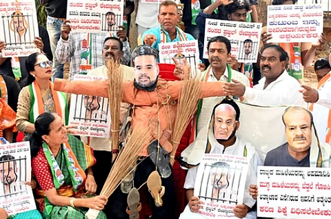 Congress leaders protest and burn photos of JD MP Prajwal Revann alleging his involvement in the sexual harassment case.