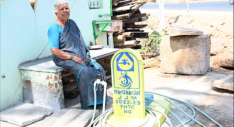 A Shanubhoganahalli resident sits near a tap that has gone dry in the village.