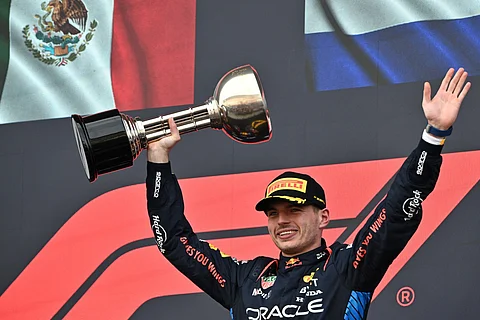 Red Bull Racing's Dutch driver Max Verstappen celebrates with the trophy on the podium after winning the Formula One Japanese Grand Prix race at the Suzuka circuit in Suzuka, Mie prefecture on April 7, 2024.
