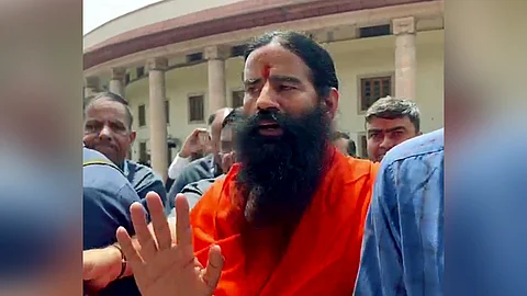 Yoga guru and Patanjali Ayurved co-founder Baba Ramdev leaves the Supreme Court after attending a hearing relating to misleading advertisements by the company in 2024.