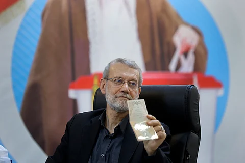 Former Iran's parliament speaker Ali Larijani shows his identification document to media while registering his name as a candidate for the June 28 presidential elections
