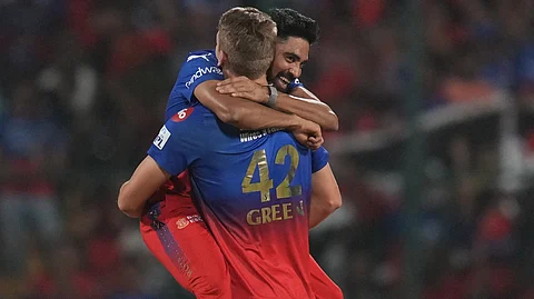 RCB's Cameron Green and Mohammed Siraj celebrate the wicket of Gujrat Titans batter Sai Sudharsan during the IPL 2024 T20 cricket match between RCB and Gujrat Titans on May 4, 2024.