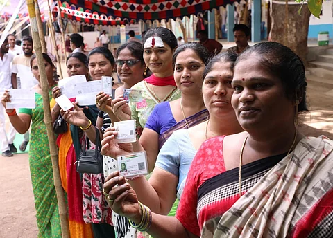 Transgender persons displaying aadhar cards before casting their vote in Khammam.