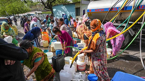 Residents fill water from a tanker amid water crisis, at the Vivekanand Camp in Chanakyapuri area of New Delhi.