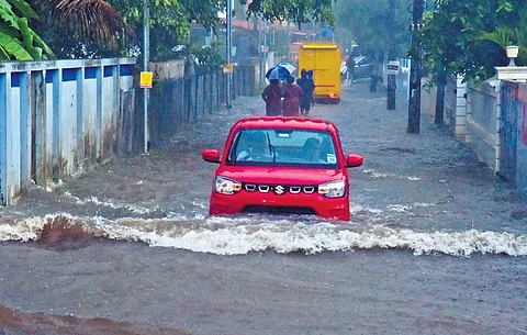Waves ripple as vehicles forge through the waterlogged Ponevazhi road at Edappally