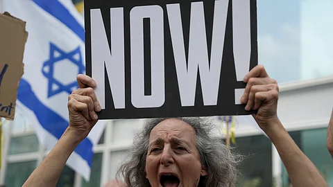 A woman holds a banner and shouts slogans with families and supporters of Israeli hostages held by Hamas in Gaza during a protest calling for their return, outside a meeting between U.S. Secretary of State Antony Blinken and families of hostages in Tel Aviv, Israel.