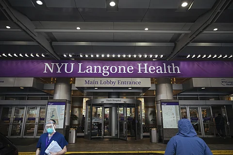 Health care workers walk in and out of the entrance at NYU-Langone Hospital on Monday, Dec. 14, 2020, in New York.