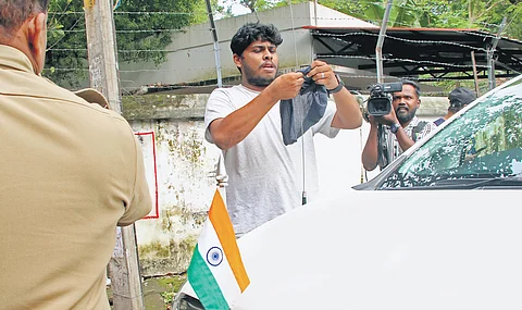 A KSU activist ties a black flag on General Education Minister V Sivankutty’s car outside his official residence, Rose House, in Thiruvananthapuram on Sunday.