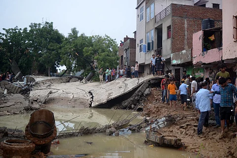 People near the debris after a water tank collapsed due to heavy rainfall, in Mathura, Sunday, June 30, 2024.