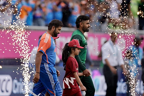 Pakistan's captain Babar Azam, right, and India's captain Rohit Sharma walk into the field before the start of the ICC Men's T20 World Cup cricket match between India and Pakistan at the Nassau County International Cricket Stadium in Westbury, New York, Sunday, June 9, 2024.