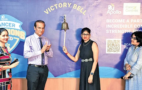 A cancer survivor, flanked by Apollo representatives, rings the ‘victory bell’ at the Apollo Cancer Centre in Hyderabad on Saturday