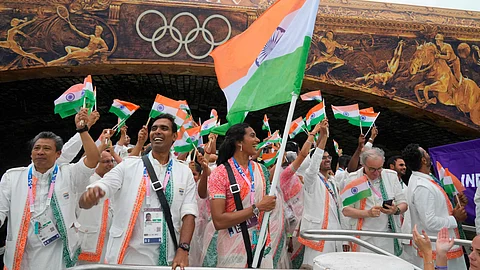 Indian athletes wave their national flags from a boat on the Seine River in Paris, France, during the opening ceremony of the 2024 Summer Olympics, Friday, July 26, 2024.
