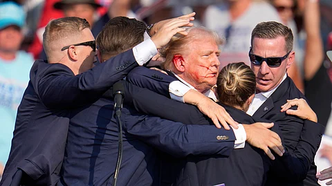 Republican presidential candidate former President Donald Trump is surrounded by U.S. Secret Service agents as he is helped off the stage at a campaign rally