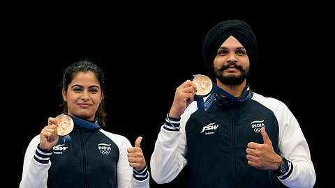 India's Manu Bhaker, left, and Sarabjot Singh pose for a photograph after winning the bronze medal in the 10m air pistol mixed team event at the 2024 Summer Olympics, Tuesday, July 30, 2024