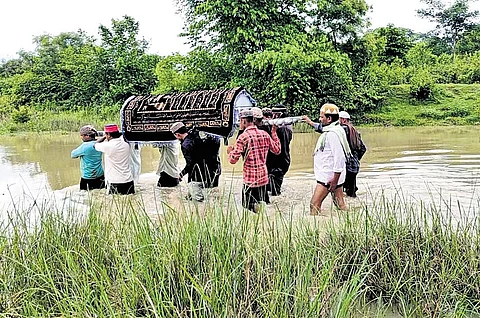 The villagers carrying a body across Kukurjhor Nal