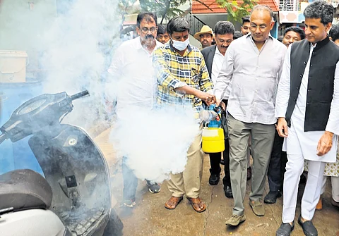 Health Minister Dinesh Gundu Rao fumigates to combat the mosquito menace in Ramaswamypalya on Friday
