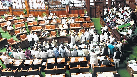 Opposition members
protest against the Congress
government in the Well of the Assembly, on Friday.