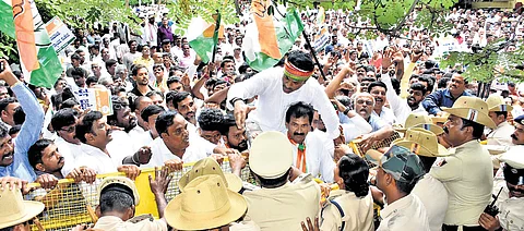 Congress workers led by KPCC spokesperson M Lakshmana protest against BJP near MUDA office in Mysuru on Friday
