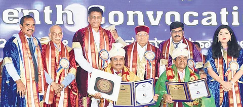 Governor Thaawarchand Gehlot presents honorary doctorates to
industrialist HG Chandrashekar and swimmer SC Naganandaswamy during the 17th annual convocation of Tumkur University on Wednesday.