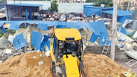Revenue officials demolishing illegal structures built on government land in Ailapur village of Ameenpur mandal, Sangareddy district on Tuesday