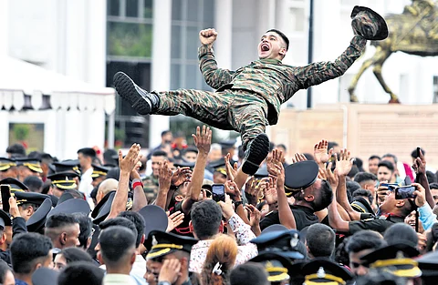 Cadets celebrate after the passing out parade on Saturday