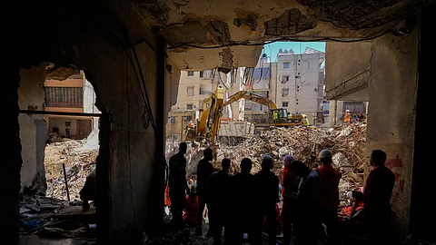 Emergency workers use excavators to clear the rubble at the site of Friday's Israeli strike in Beirut's southern suburbs, Lebanon