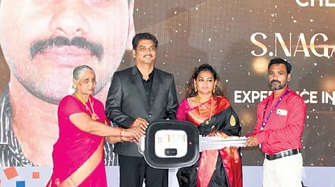 An employee receives a key to a car at an event on Saturday