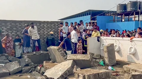 Officials and others gather at the site where at least three labourers were killed and seven others suffered injuries after a makeshift water tank collapsed at a labour camp, in Pune district,
