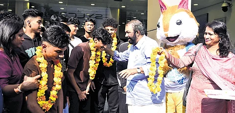 Education Minister V Sivankutty receives the students from UAE after they landed in Kochi for the sports meet on Monday
