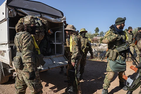 Syrian opposition fighters get off a truck as they enter the village of Anjara, western outskirts of Aleppo, Syria, Thursday Nov. 28, 2024, part of their major offensive on government-controlled areas in the country's northwestern Syria.