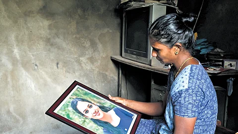 Sheeja, Induja’s mother, sits numb and silent, looking at her daughter’s photograph
