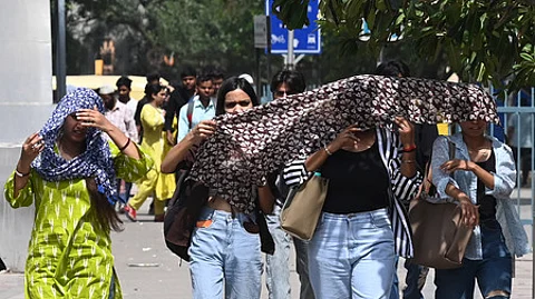 Commuters brave the heat wave during a hot summer afternoon at Sarojini Nagar Market as the temperature rises, on May 18, 2025 in New Delhi.