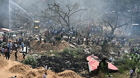 People near the debris of the Air India plane that crashed moments after taking off from the airport, in Ahmedabad, Thursday, June 12, 2025.