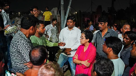 AAP MLA and Leader of Opposition Atishi meets with people at the Bhoomiheen Camp in Kalkaji, Delhi, on Wednesday.