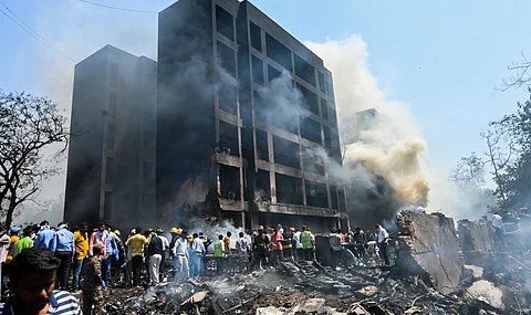 People gather at the site after an Air India plane crashed moments after taking off from the airport, in Ahmedabad, Thursday, June 12, 2025.