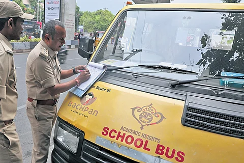 A motor vehicles inspector issues a spot fine for a school bus near the Khairatabad RTA office in Hyderabad