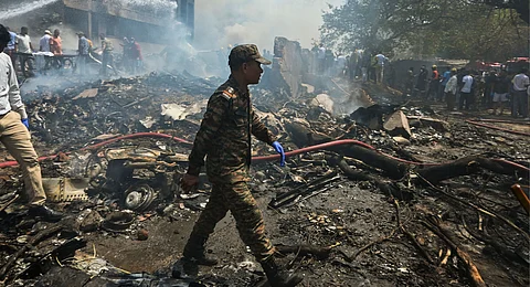 A security personnel at the site after an Air India plane crashed moments after taking off from the airport, in Ahmedabad, Thursday, June 12, 2025. The London-bound plane was carrying 242 passengers.