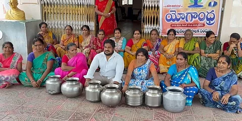 The residents of Parvathipuram town staging protest with empty bins at municipal office demanding for drinking water supply.