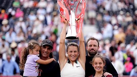Tatjana Maria of Germany holds the trophy as she celebrates with her family after winning