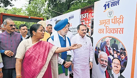 Union Minister Hardeep Singh Puri with Delhi BJP President Virendra Sachdeva and Chief Minister Rekha Gupta during the inauguration of an exhibition.