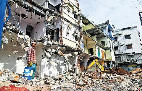 A worker oversees the demolition of residential and commercial properties for the setting up of Airport Metro in Old City of Hyderabad