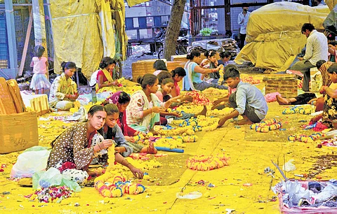 The air is thick with the scent of fresh flowers and the chatter of bargaining voices.