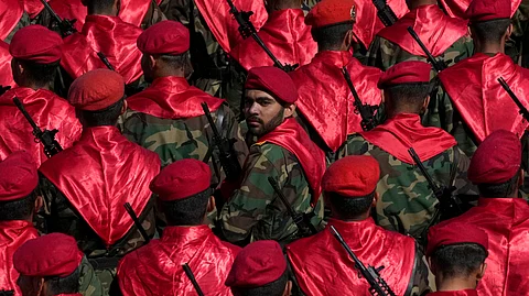 An Iranian army member looks back among others as they conclude their march during a parade commemorating National Army Day in front of the shrine of the late revolutionary founder Ayatollah Khomeini, just outside Tehran, Iran, on Friday, April 18, 2025.