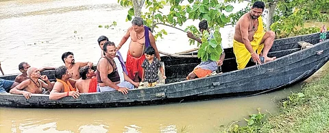 Residents of a flooded village are travelling on a boat in the Balasore district