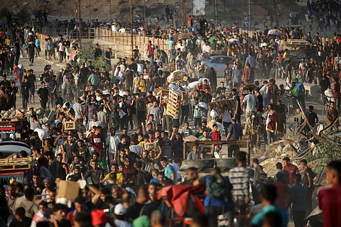 Palestinians gather at an aid distribution point set up by the Gaza Humanitarian Foundation (GHF), near the Nuseirat refugee camp in the central Gaza Strip on June 25, 2025.