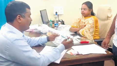 ACB sleuths interact with an RTA employee during raids on Thursday